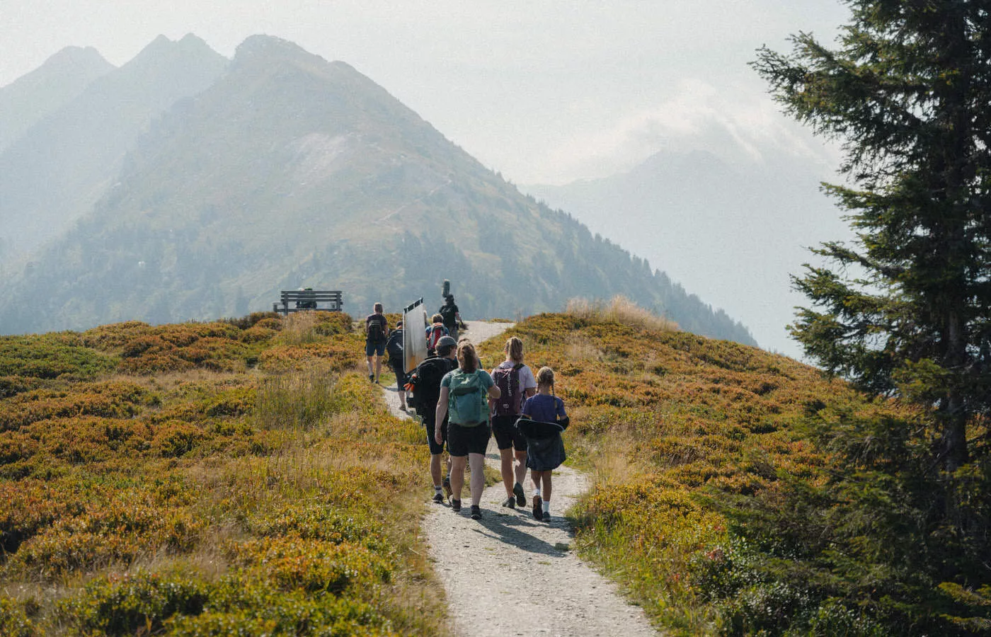 Notic-Filmproduktionsteam bei der Erstellung einer Outdoor-Tourismuskampagne in der Region Schladming. Wandergruppe auf einem Alpenpfad, umgeben von malerischen Bergen und unberührter Natur.